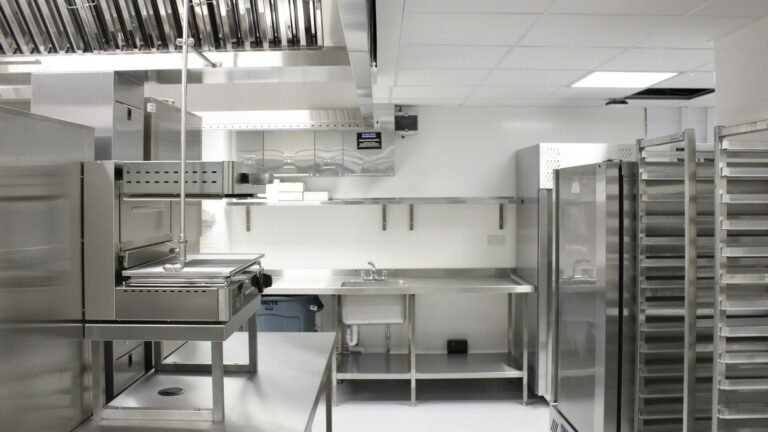 Professional commercial kitchen with stainless steel equipment and storage