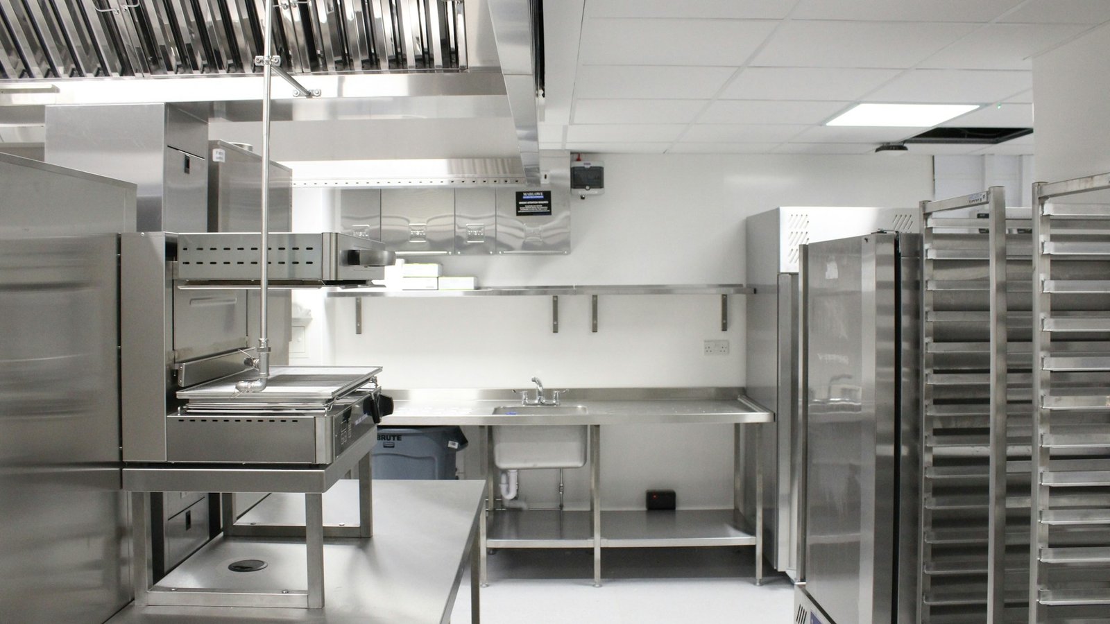 Professional commercial kitchen with stainless steel equipment and storage