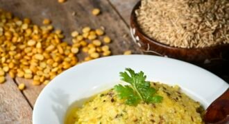 Yellow rice-and-lentil dish on a white plate beside uncooked rice and pulses