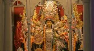 Durga idol with ornate decorations and flower garlands at Chhatu Babu Latu Babu Thakur Bari in Kolkata