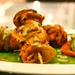 Paneer tikka pieces with vegetables on skewers