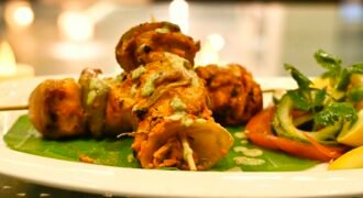 Paneer tikka pieces with vegetables on skewers