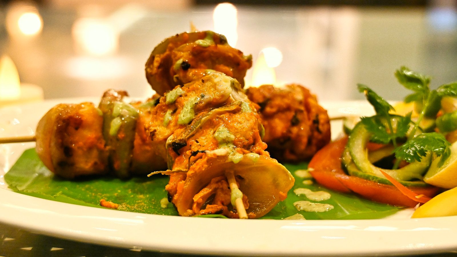 Paneer tikka pieces with vegetables on skewers