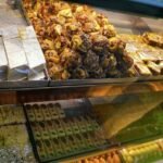 Assorted Indian mithai with shiny silver leaf displayed in a sweet shop; illustrative photograph