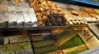 Assorted Indian mithai with shiny silver leaf displayed in a sweet shop; illustrative photograph
