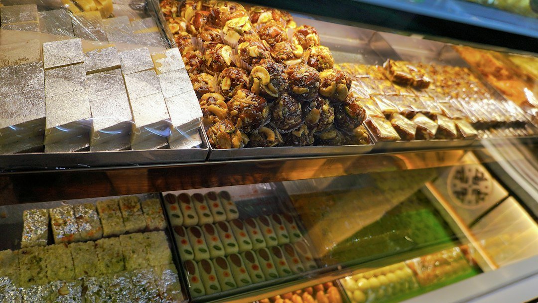 Assorted Indian mithai with shiny silver leaf displayed in a sweet shop; illustrative photograph