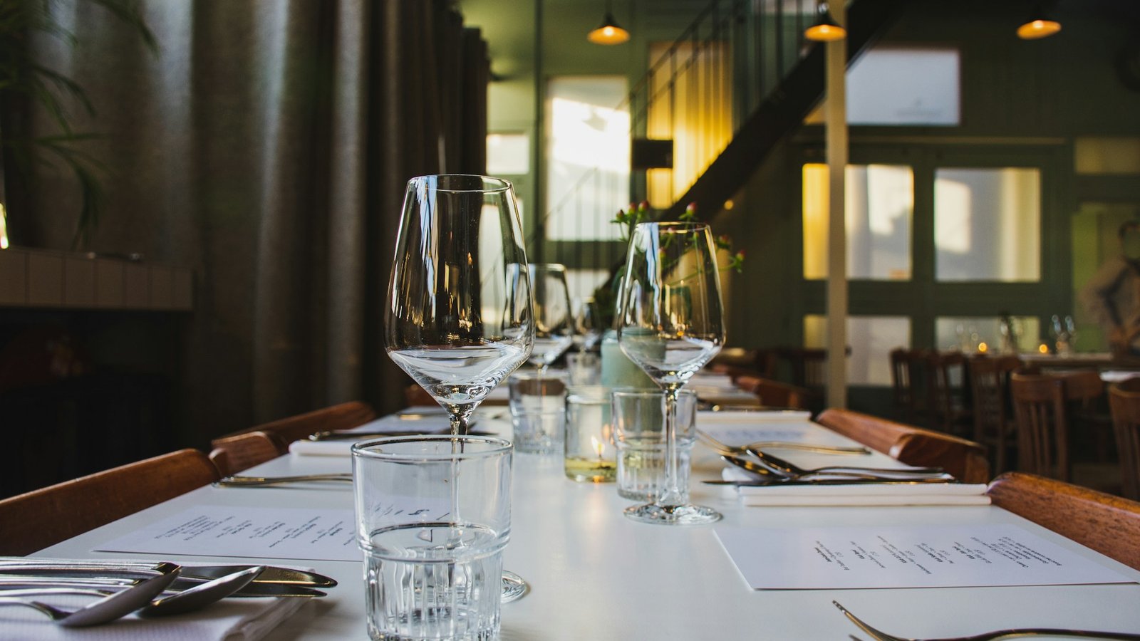 Set restaurant dining table with glasses and place settings