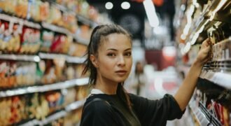 Shopper selecting packaged food from a grocery shelf; illustrative photograph, no FSSAI endorsement shown