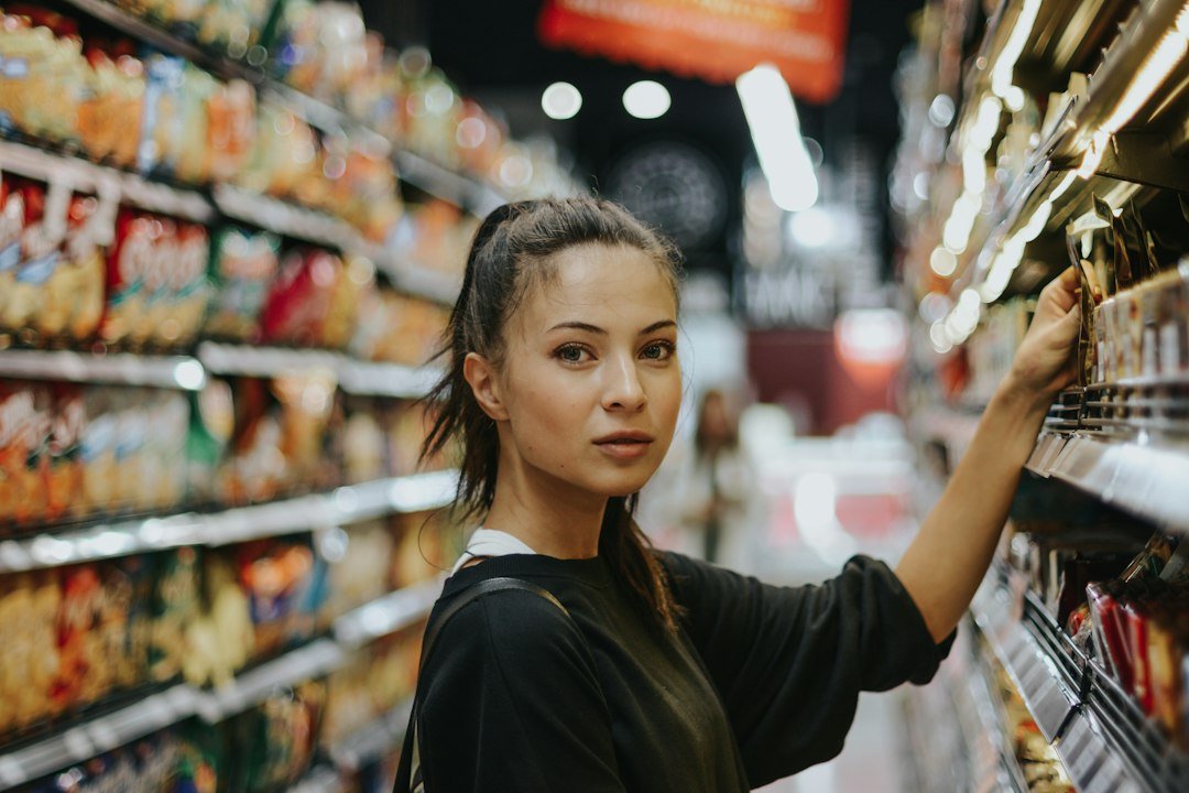 Shopper selecting packaged food from a grocery shelf; illustrative photograph, no FSSAI endorsement shown