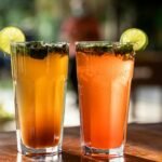 Two mojito-style drinks with lime, mint and ice