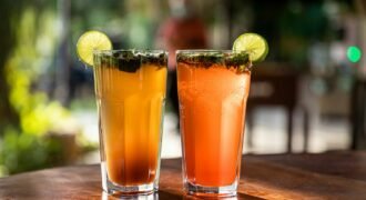 Two mojito-style drinks with lime, mint and ice