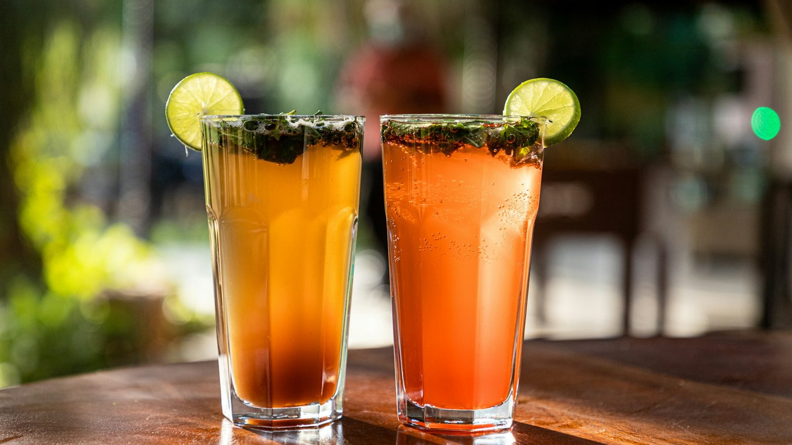 Two mojito-style drinks with lime, mint and ice