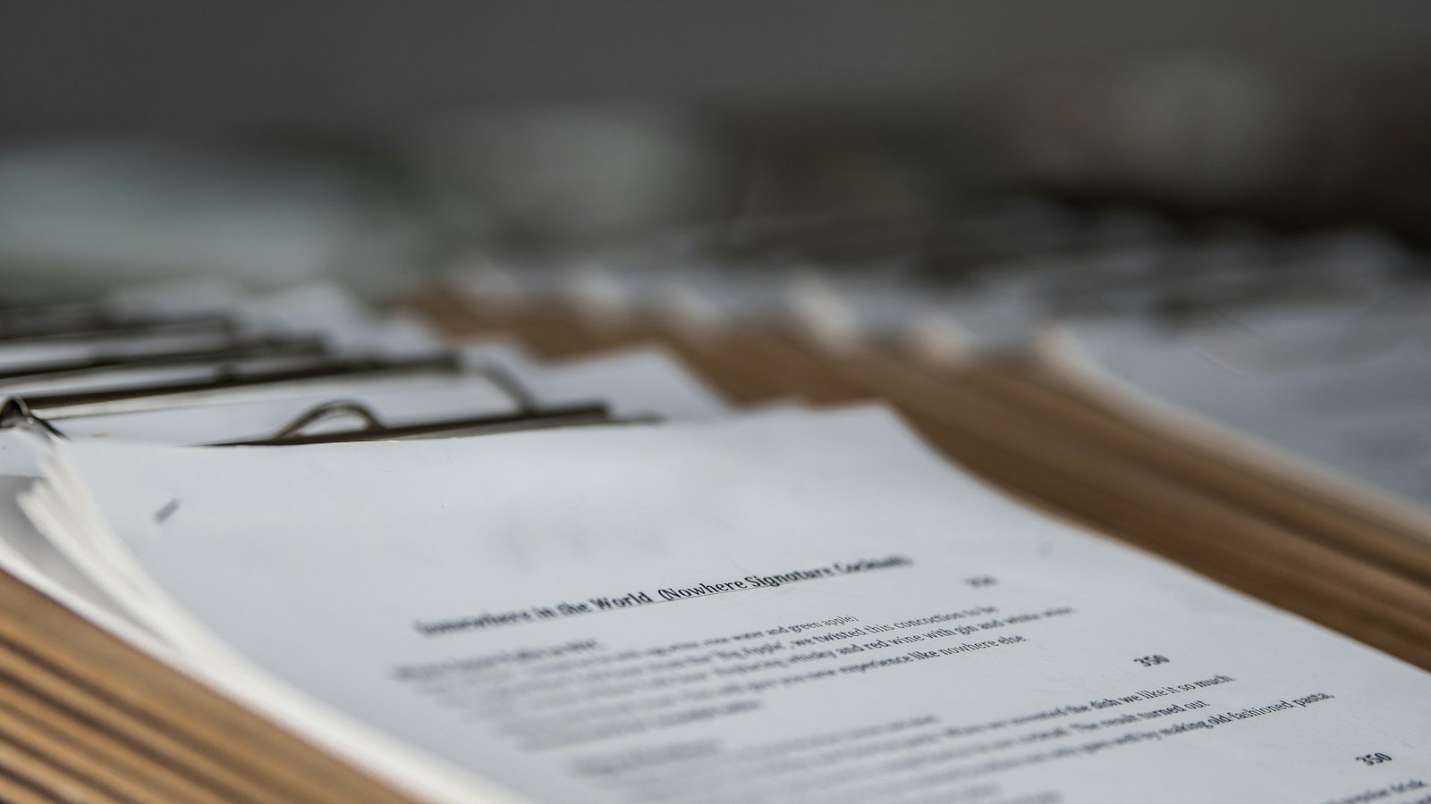 Printed restaurant menus on wooden clipboards, photographed in close-up